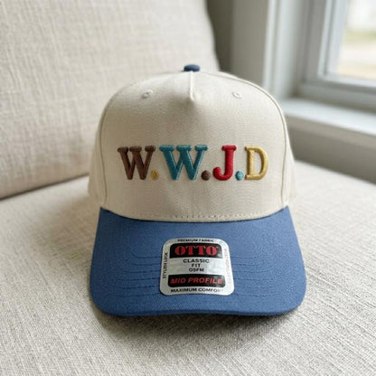 Front view of W.W.J.D embroidered trucker hat resting on a cushion