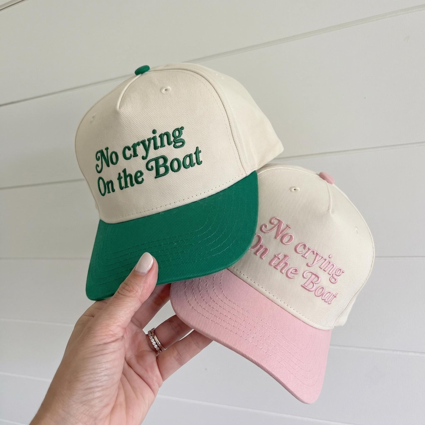 Cream and forest green two-tone trucker hat embroidered with “No Crying On the Boat”