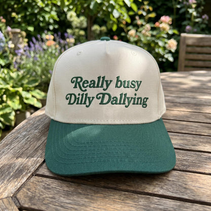 Two-tone Really Busy Dilly Dallying trucker hat displayed outdoors on a wooden table