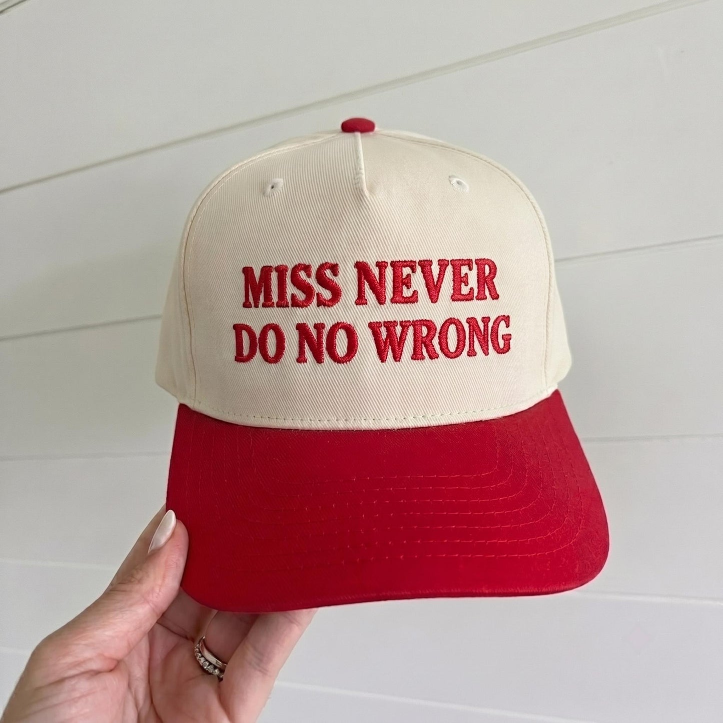 Cream and red two-tone trucker hat embroidered with Miss Never Do No Wrong