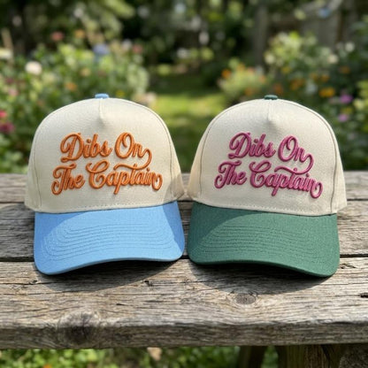 Cream Dibs On The Captain trucker hats with light blue and forest green bills outdoors