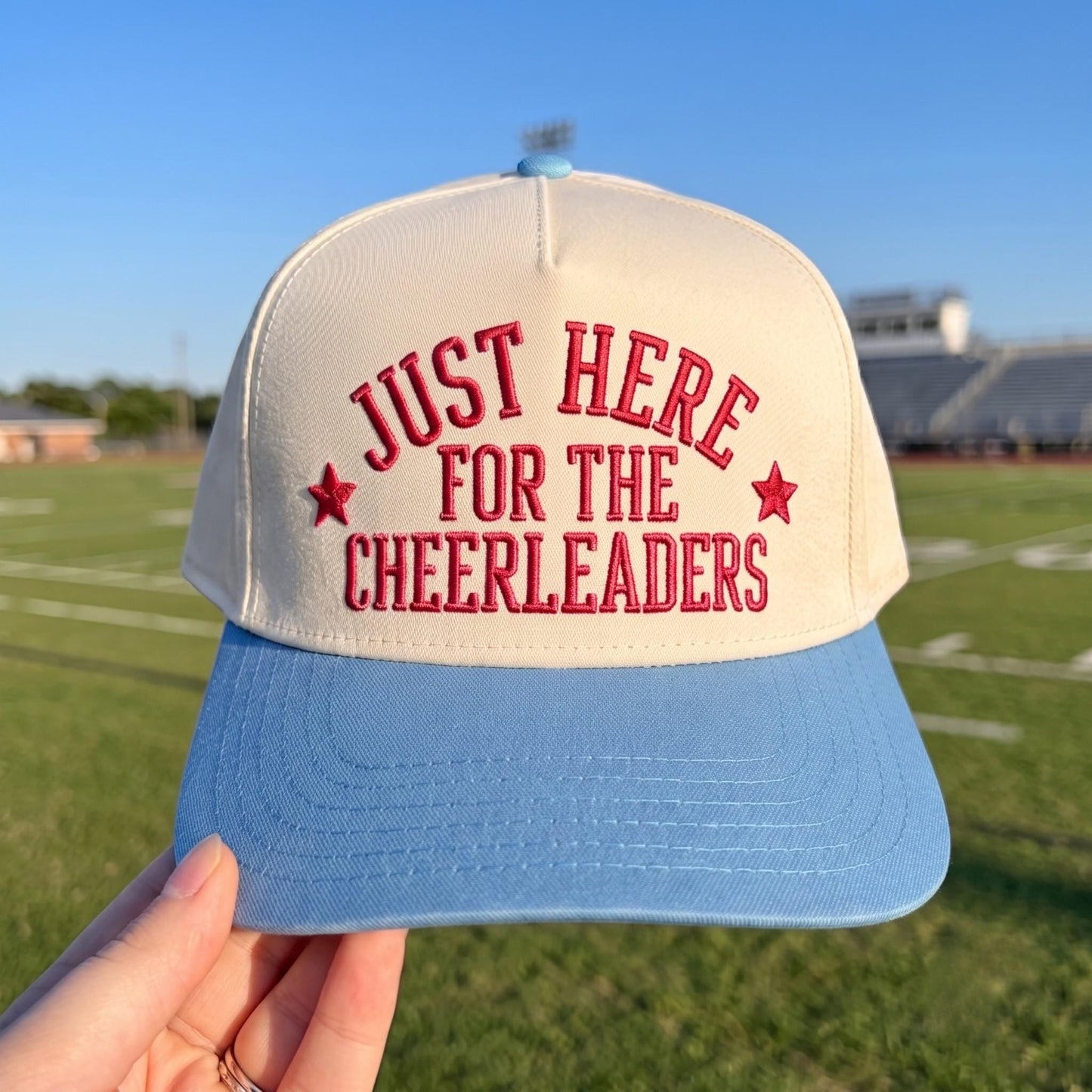 Light crown and blue brim embroidered cheerleader hat reading Just Here for the Cheerleaders with star accents