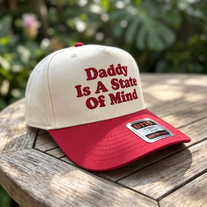 Embroidered Daddy Is a State Of Mind trucker hat displayed outdoors