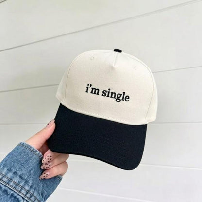 Two-tone cream and black trucker hat with “i’m single” embroidered on the front