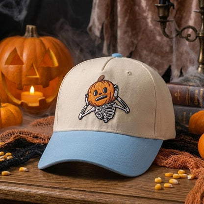 Embroidered pumpkin skeleton Halloween cap displayed on a wooden table