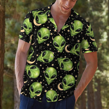 Model wearing a green alien face Hawaiian shirt in a casual outdoor setting