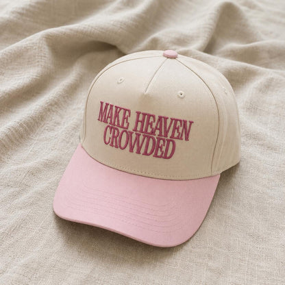 Two-tone cream and pink trucker hat embroidered with Make Heaven Crowded lettering