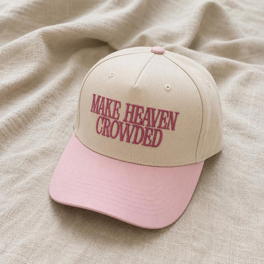 Two-tone cream and pink trucker hat embroidered with Make Heaven Crowded lettering