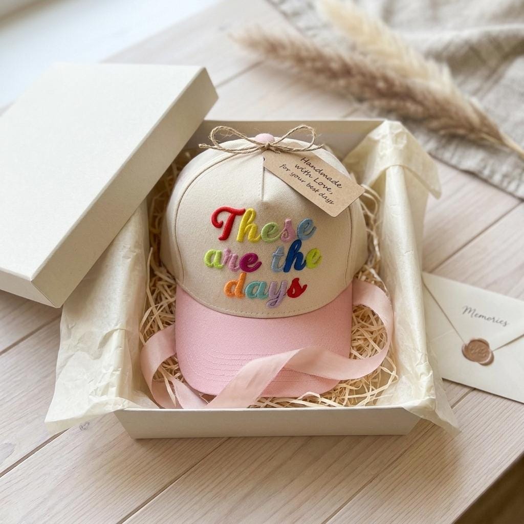 Two-tone embroidered hat with pink brim presented in a gift box
