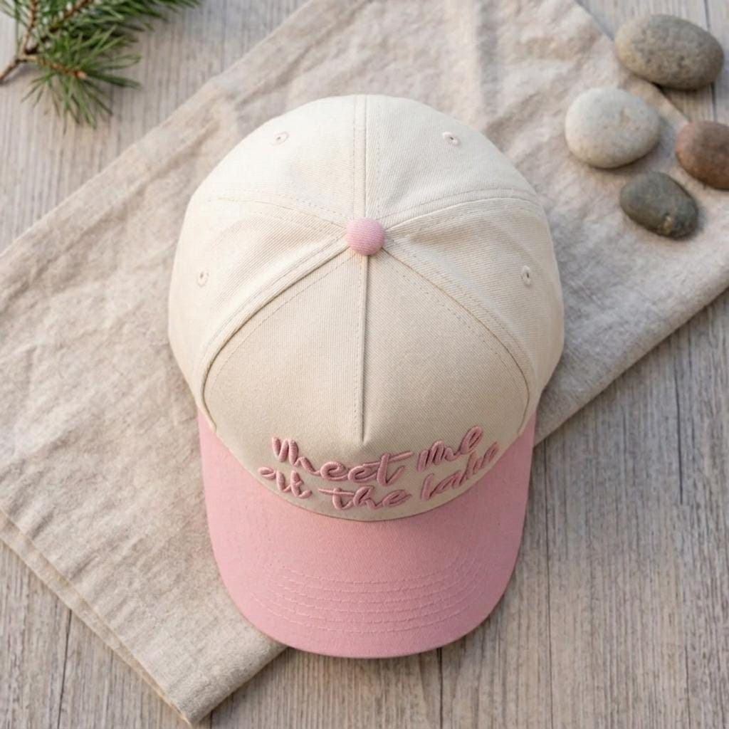 Top view showing the cream crown, pink brim, and pink button on the cap