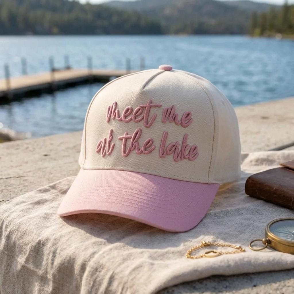 Embroidered Meet Me at the Lake cap styled beside a lakeside dock
