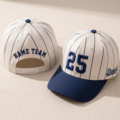 Cream and navy pinstripe baseball hat shown from the front and back with embroidered 25 and NAME TEAM details