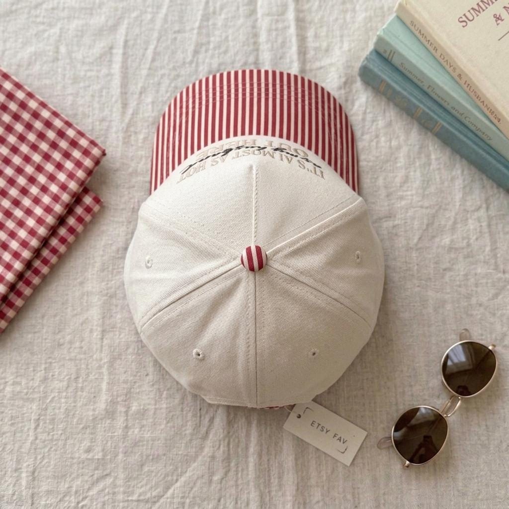 Top view of cream baseball cap showing red striped crown and brim