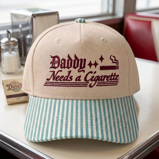Khaki embroidered Daddy Needs a Cigarette hat with light blue striped bill