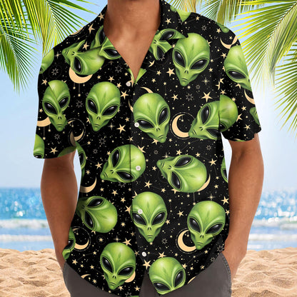 Model wearing a black alien Hawaiian shirt with green alien faces and star details at the beach