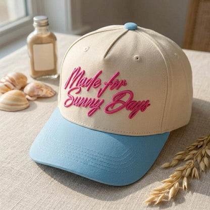 Cream summer hat with blue brim and raised Made for Sunny Days embroidery indoors