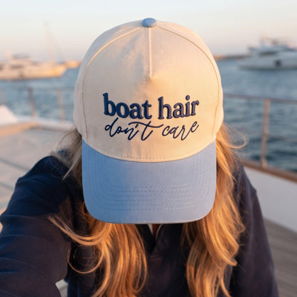 Boat Hair Don't Care hat with a light blue brim worn on a boat
