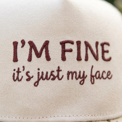 Close-up of burgundy “I’M FINE, it’s just my face” embroidery