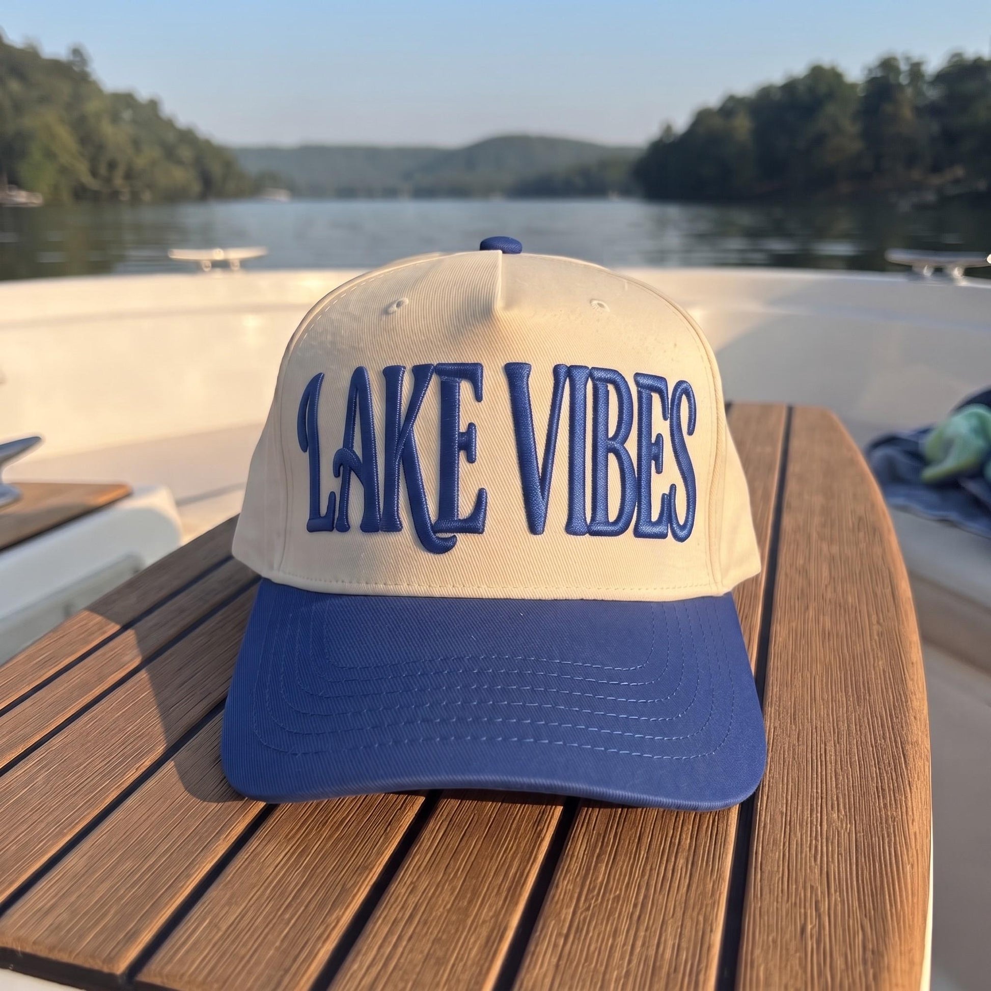 Front view of cream Lake Vibes cap with blue brim and raised lettering