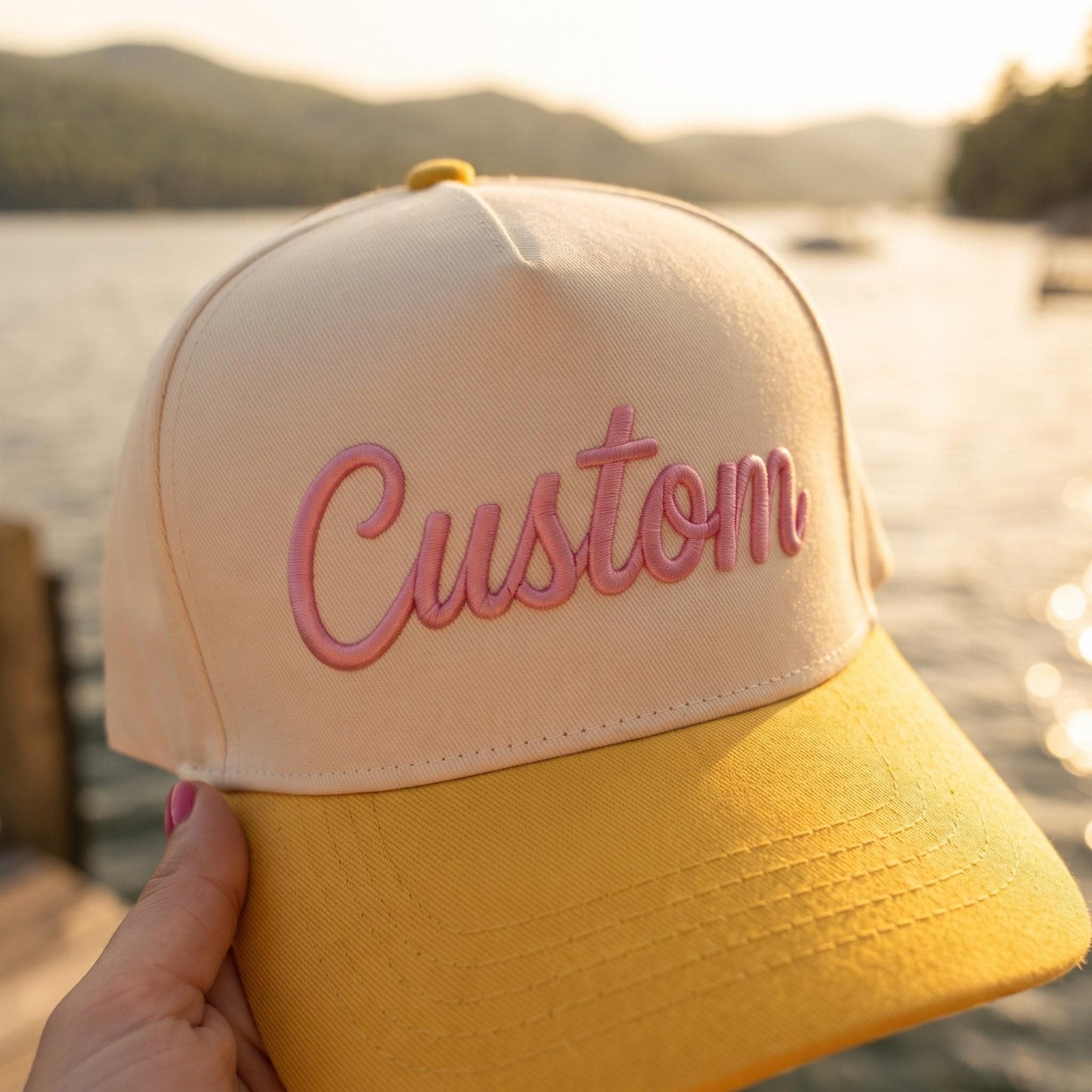 Cream and yellow embroidered hat with pink script Custom lettering at sunset