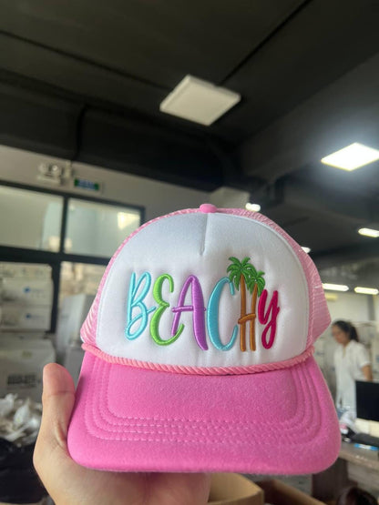 Front view of a pink and white mesh beach hat with colorful palm tree embroidery