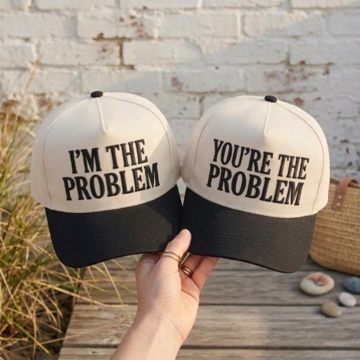 Matching cream and black two-tone trucker hats with complementary problem phrases