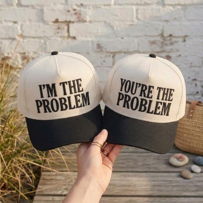 Matching cream and black two-tone trucker hats with complementary problem phrases