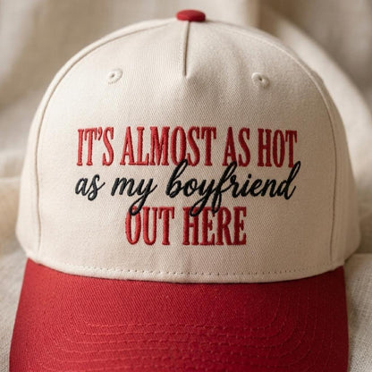 Close-up of red and black lettering on a cream trucker cap