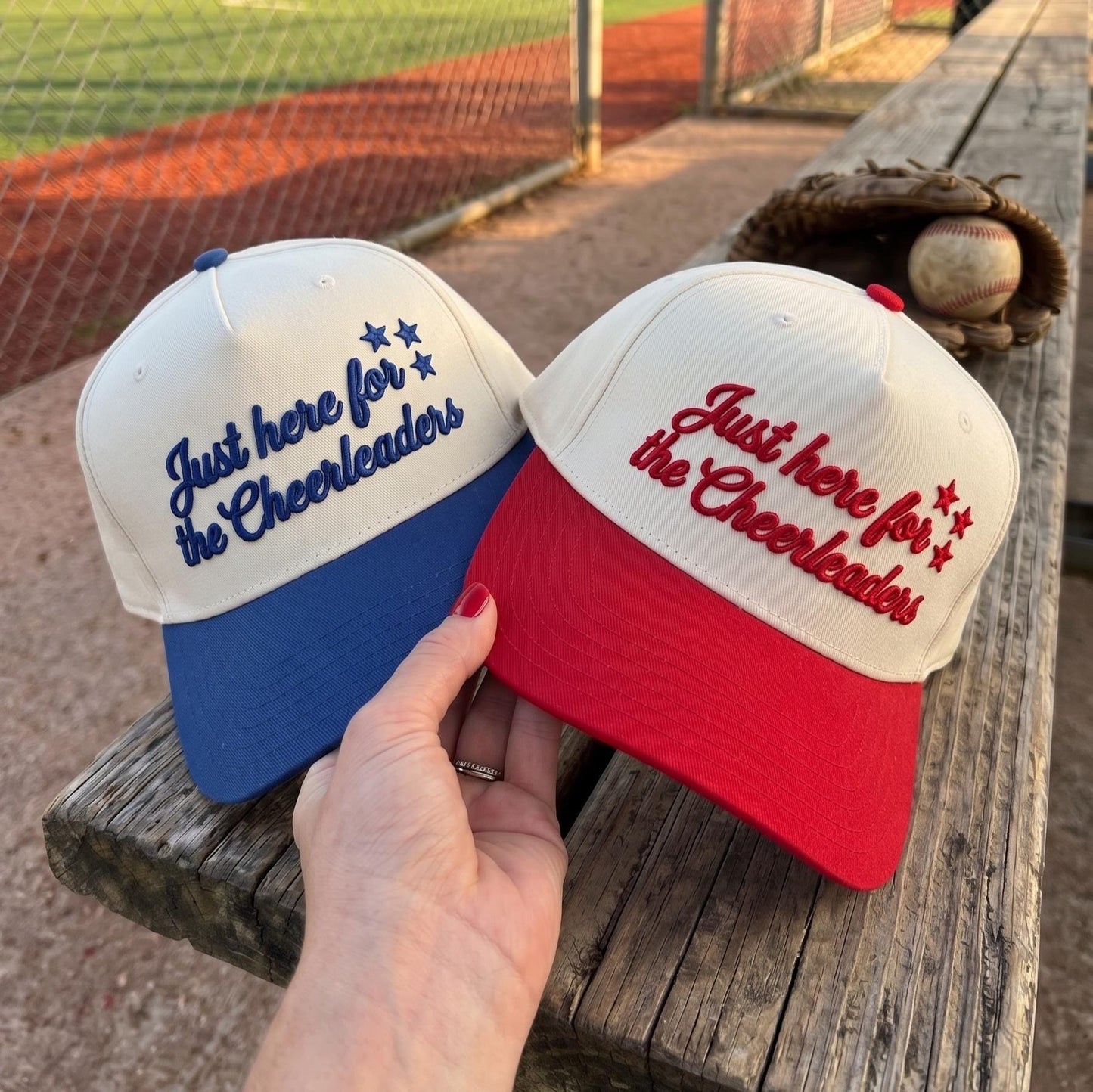 Two embroidered cheerleader hats shown together with blue and red brims