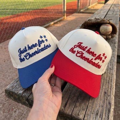 Two embroidered cheerleader hats shown together with blue and red brims