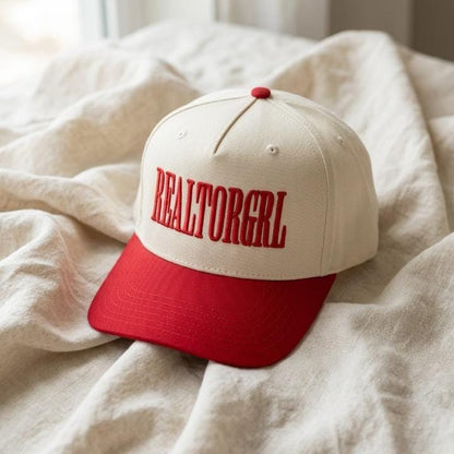 REALTORGRL embroidered cap resting on a bed