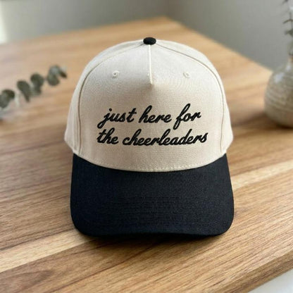 Front view of the embroidered cheerleader hat resting on a wooden table
