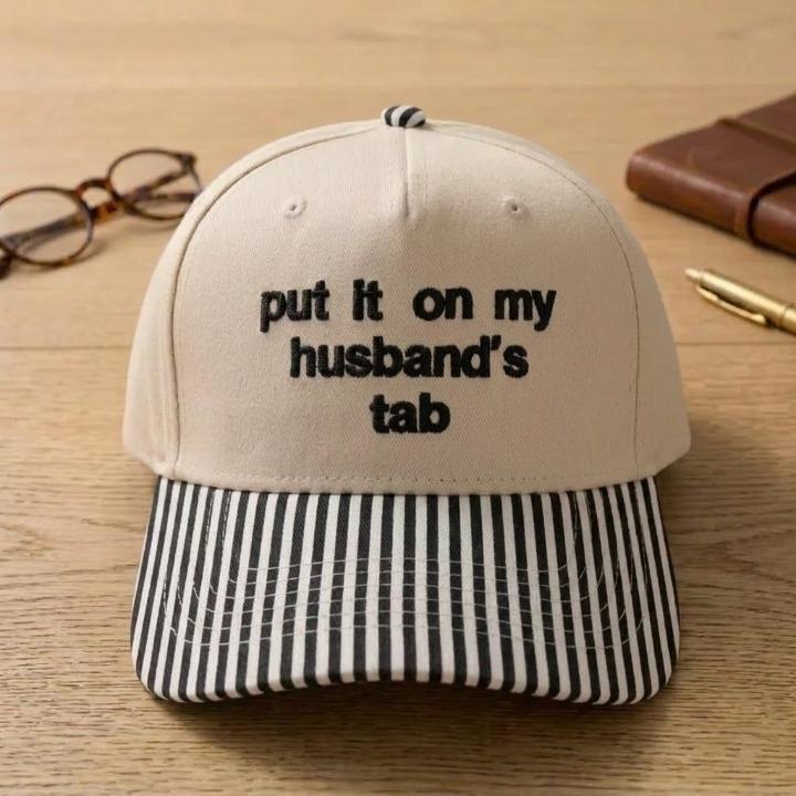 Khaki baseball cap with black striped brim and embroidered husband’s tab phrase
