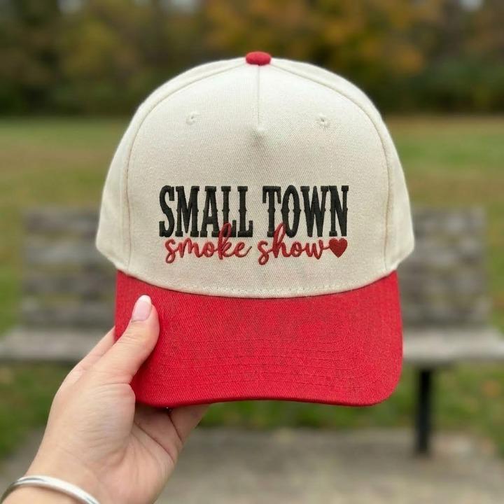 Cream and red two-tone trucker cap with embroidered Small Town Smoke Show lettering and heart accent