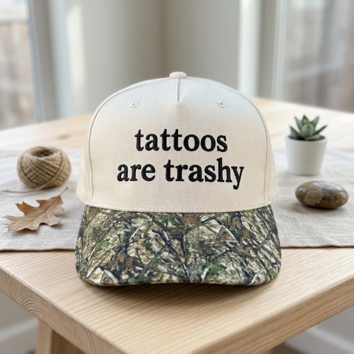 Cream statement hat with black embroidered text displayed on a table