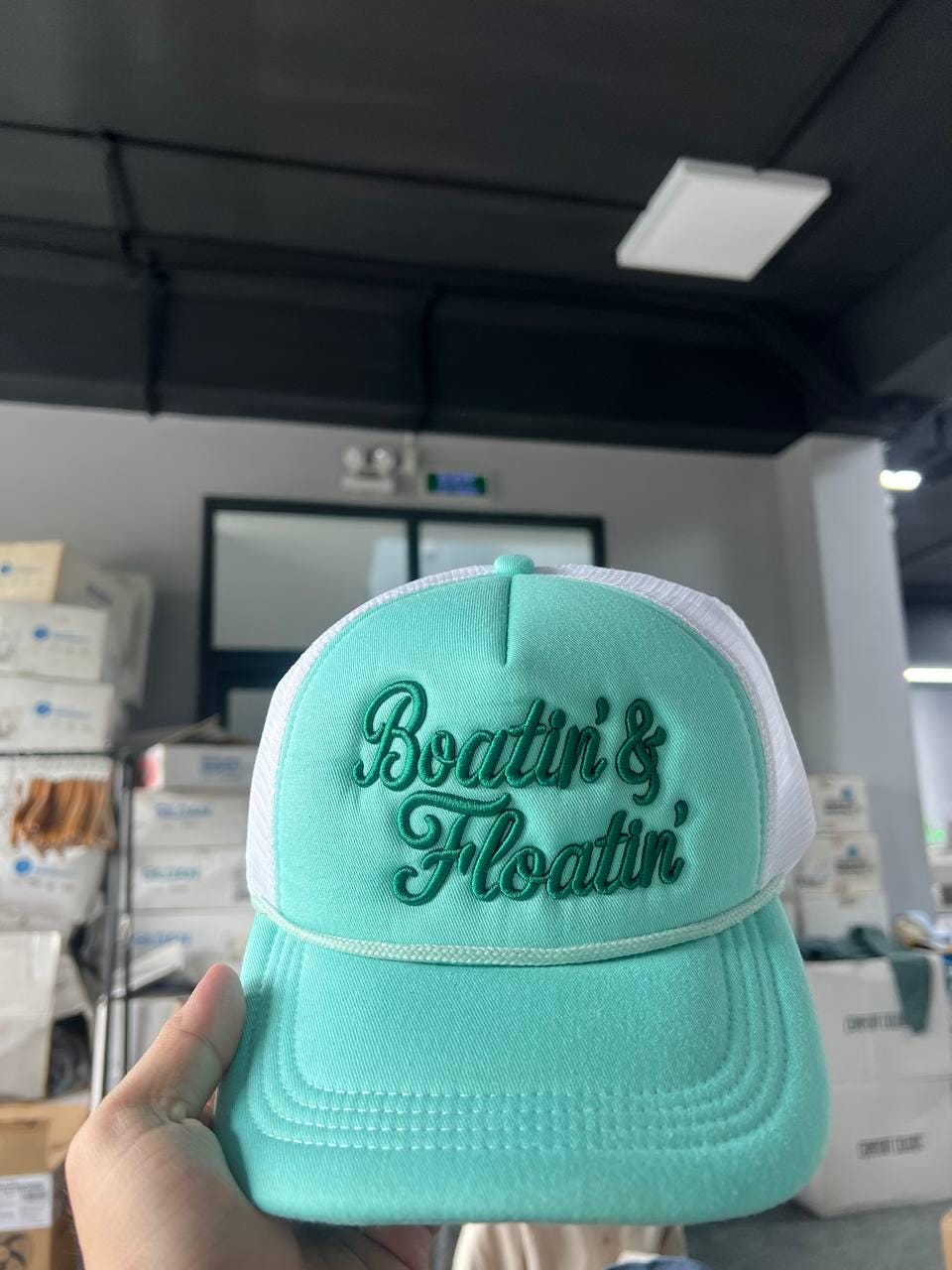Aqua Boatin' & Floatin' trucker hat displayed indoors