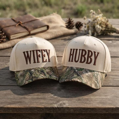 Wifey and Hubby embroidered couple hats resting on a wooden table