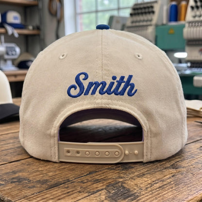Back view of a light embroidered hat showing the personalized name Smith and an adjustable snapback closure
