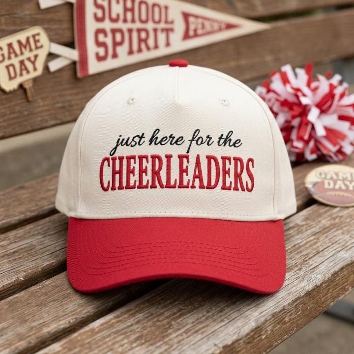 Front view of cheerleaders embroidered cap with red bill and cream crown