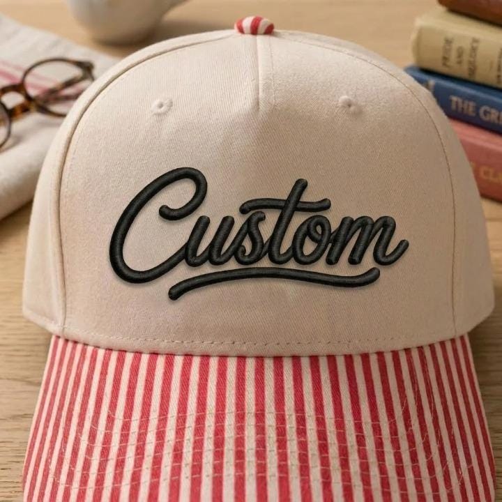 Close-up of khaki Custom script hat with red striped brim