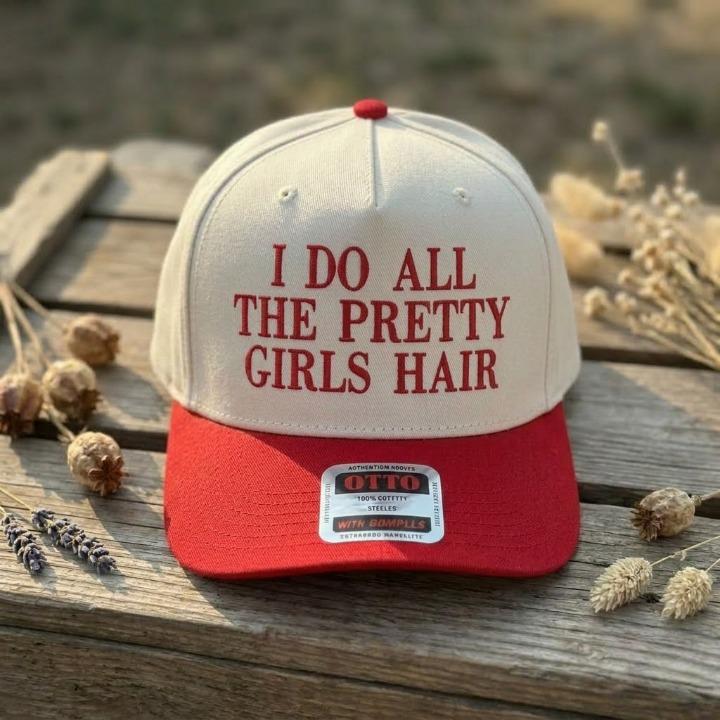 Cream and red two-tone trucker hat with funny hair stylist lettering