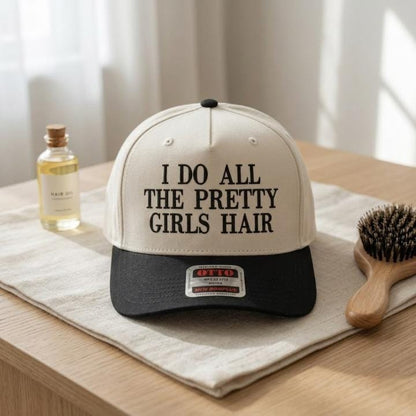 Front view of cream and black pretty girls' hair trucker hat on a tabletop