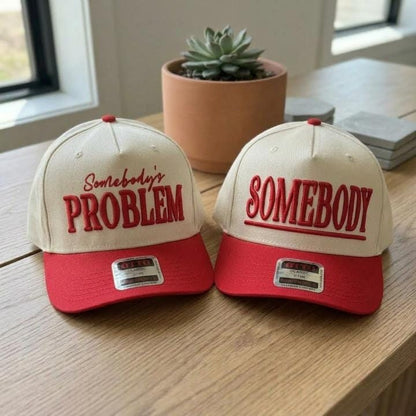 Two cream and red embroidered trucker hats with bold statement embroidery
