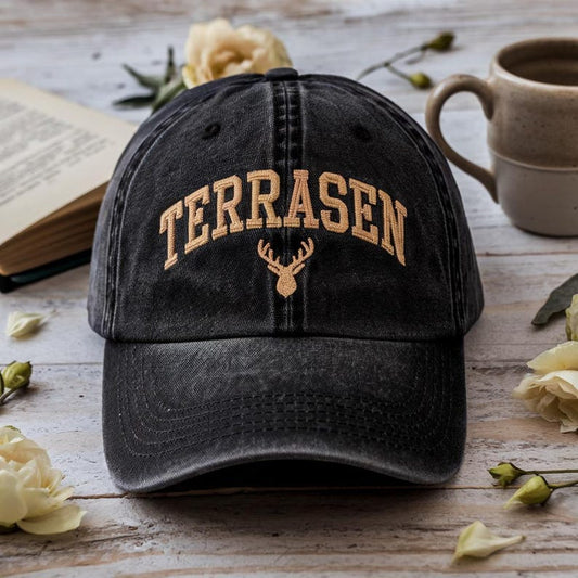 Black washed dad hat with “Terrasen” embroidered in beige and a golden stag crest